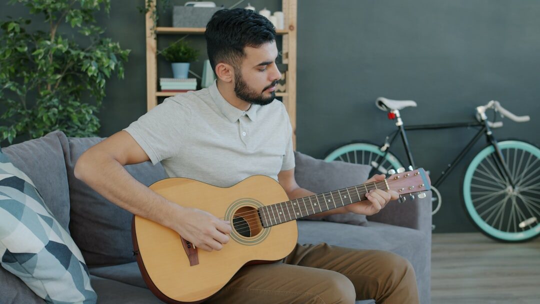 man playing guitar at home