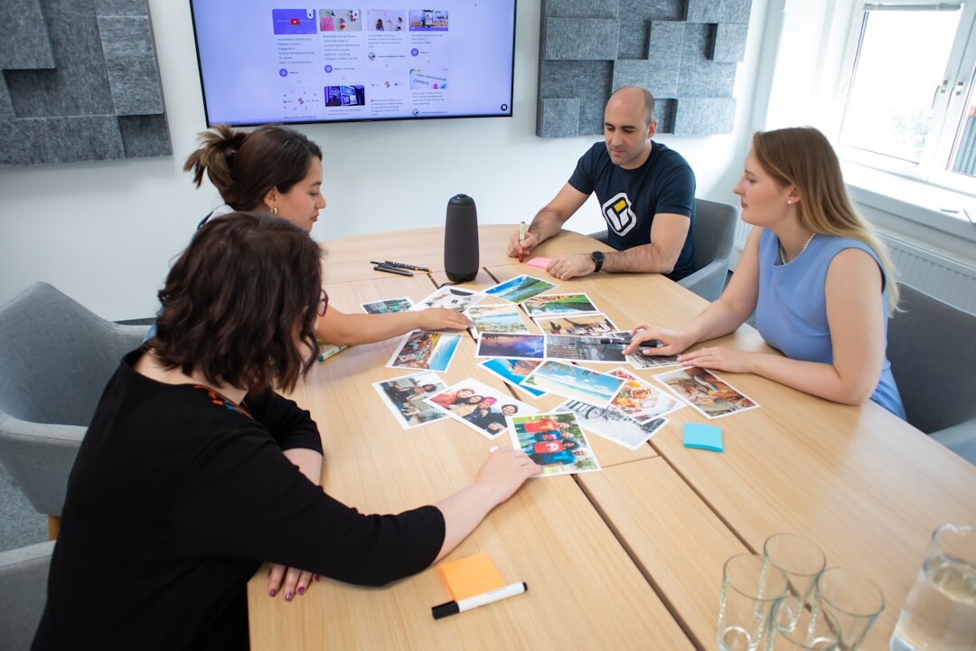 Wide editorial photograph of a magazine team reviewing photo layouts